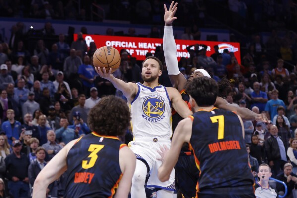 Người bảo vệ Golden State Warriors Stephen Curry (30) chuẩn bị sút, ghi bàn thắng vào rổ ở giây cuối cùng, khi người bảo vệ Oklahoma City Thunder Josh Giddey (3), tiền đạo Chet Holmgren (7) và người bảo vệ Luguentz Dort, hậu vệ phải, bảo vệ trong một pha cản phá Trận đấu bóng rổ trong mùa giải NBA vào Thứ Sáu, ngày 3 tháng 11 năm 2023, tại Thành phố Oklahoma.  (Ảnh AP / Hóa đơn Nate)